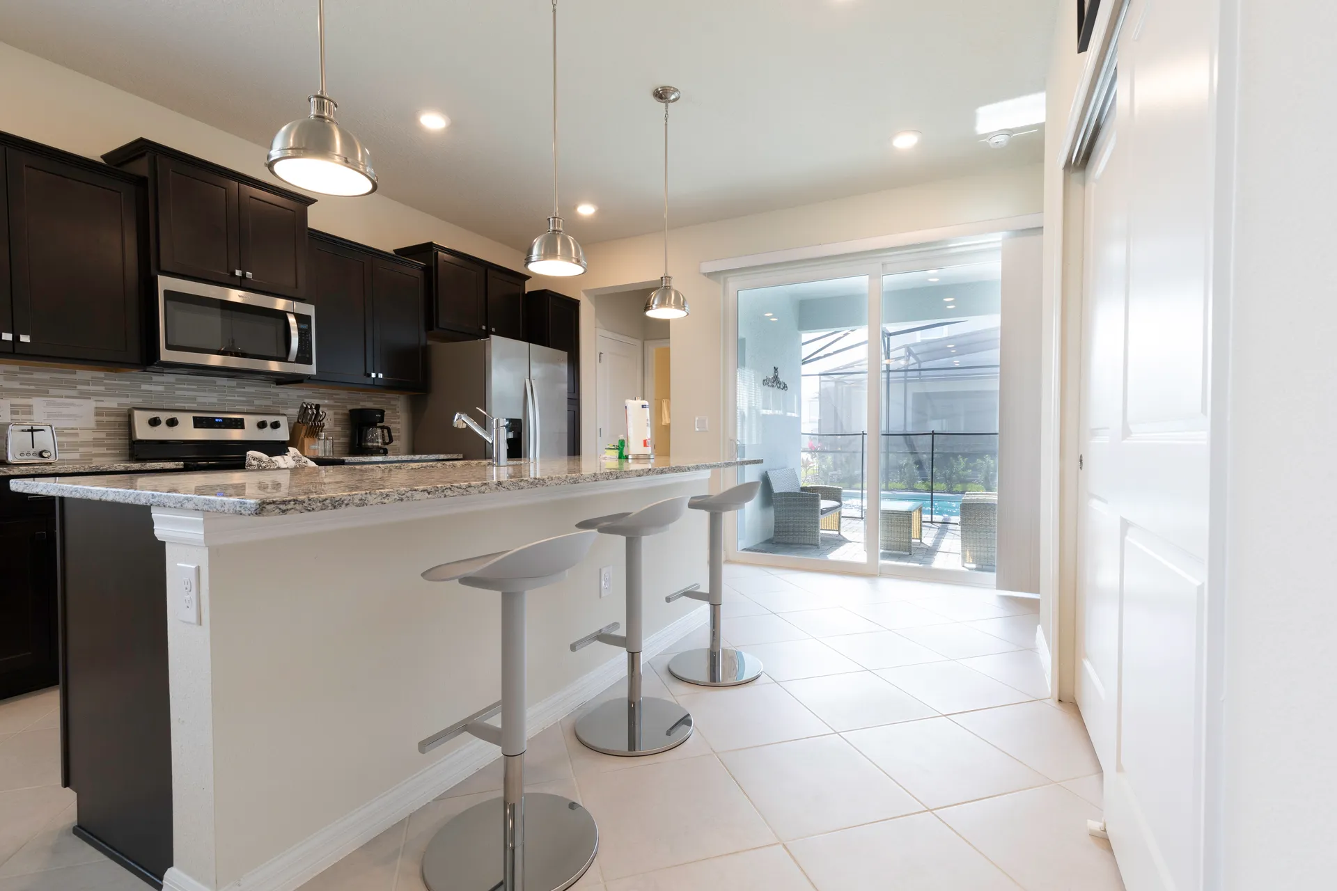 Kitchen with island and breakfast bar at the rental near Disney